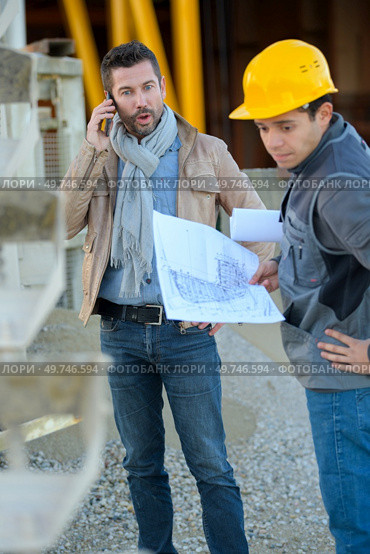 engineer and worker with cell phone on a transformer. Стоковое фото, агентство Ingram Publishing / Фотобанк Лори