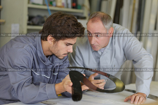 engineer checking trainees work on factory floor. Стоковое фото, агентство Ingram Publishing / Фотобанк Лори