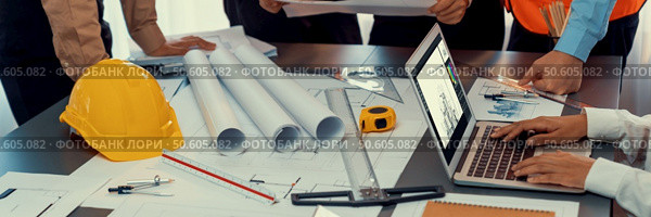 Engineer partner drawing and working on blueprint design together on office table for architectural building construction project. Architect drafting interior blueprint layout. Insight. Engineer partner drawing and working on blueprint design together. Insight. Стоковое фото, агентство Ingram Publishing / Фотобанк Лори