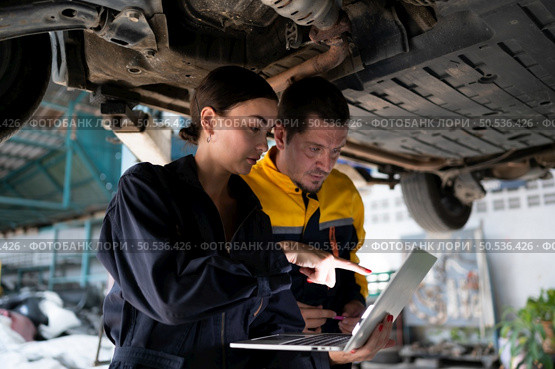 Engineers and auto repair technicians must use technology to detect faults in the operation of the engine of customer cars brought to repair in the garage. Стоковое фото, агентство Ingram Publishing / Фотобанк Лори