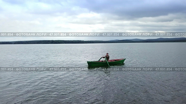 Enjoy the peaceful activity of kayaking on a serene lake, surrounded by natures tranquility. Стоковое фото, фотограф David Kashakhi / Фотобанк Лори