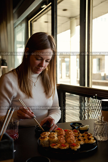 Enjoying a Delightful Sushi Feast With Friends in a Modern Eatery During a Sunny Afternoon. Стоковое фото, фотограф Aleksandr Golubev / Фотобанк Лори