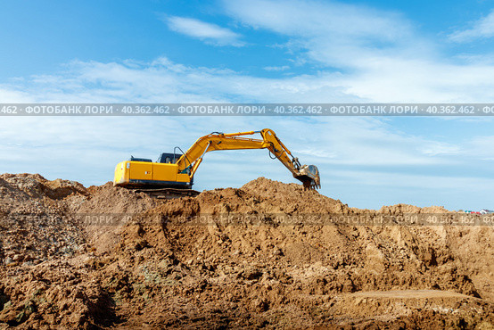 Excavator dig the trenches at a construction site. Trench for laying external sewer pipes. Sewage drainage system for a multi-story building. Digging the pit foundation. Стоковое фото, фотограф Дмитрий Головач / Фотобанк Лори