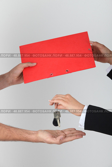 Exchanging keys and a folder. Стоковое фото, агентство Ingram Publishing / Фотобанк Лори