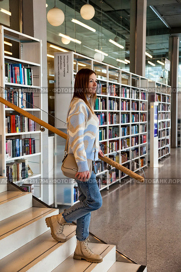 Exploring a Modern Library While Navigating the Stylish Staircase in Early Afternoon Light. Стоковое фото, фотограф Aleksandr Golubev / Фотобанк Лори