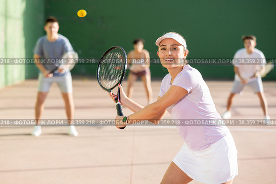 Expressive resolved fit girl playing frontenis ball friendly match on court. Стоковое фото, фотограф Яков Филимонов / Фотобанк Лори