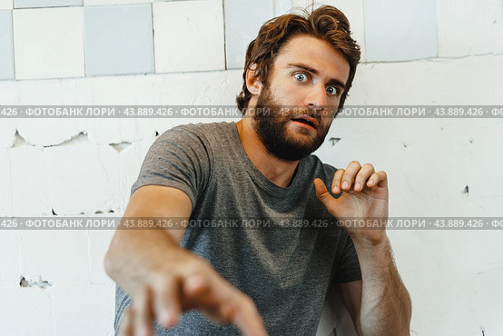 Expressive young bearded man scared and nervous. Стоковое фото, фотограф Сергей Толмачёв / Фотобанк Лори