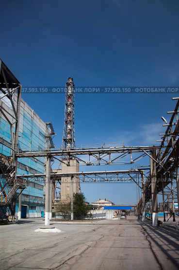 Factory chimney of phosphoric fertilizers plant with girder constructions and pipelines on blue sky. Стоковое фото, фотограф Alexey Rezvykh / Фотобанк Лори