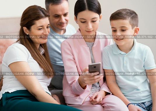 family members using mobile phone. Стоковое фото, агентство Ingram Publishing / Фотобанк Лори