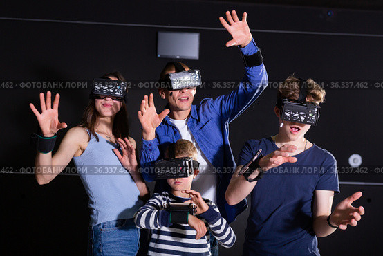 Family with children playfully poses in virtual reality glasses. Стоковое фото, фотограф Яков Филимонов / Фотобанк Лори