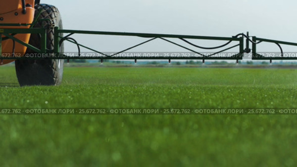 Farm Fetilizer Watering In The Green Lawn Field. Стоковое видео, видеограф Станислав Панкратов / Фотобанк Лори