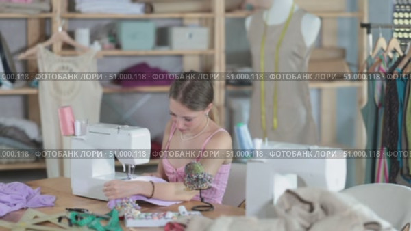 Fashion designer sews clothes on a sewing machine. Dressmaker works in the workshop. Clothing making process. Стоковое видео, видеограф Яков Филимонов / Фотобанк Лори