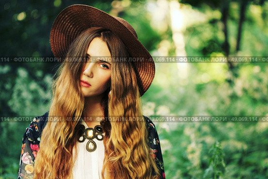 Fashion portrait of beautiful hippie young woman wearing boho chic clothes and summer hat outdoors. Soft warm vintage color tone. Artsy bohemian style. Стоковое фото, агентство Ingram Publishing / Фотобанк Лори
