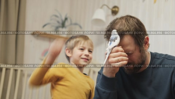 Father and son enjoying at home. Young boy and his daddy playing with funny pet budgerigar parrot. Happy family. Tamed budgie parakeet. People take care of and play with bird. Cute domestic animals. Стоковое видео, видеограф Марина Демидюк / Фотобанк Лори