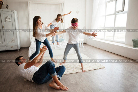 father lying floor while family playing blind man s buff home. Стоковое фото, агентство Ingram Publishing / Фотобанк Лори