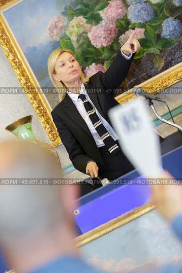 female auctioneer directing the bids. Стоковое фото, агентство Ingram Publishing / Фотобанк Лори