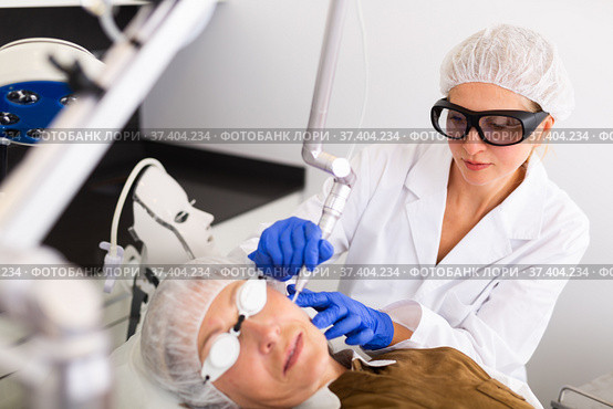 Female beautician making laser resurfacing of aged female client. Стоковое фото, фотограф Яков Филимонов / Фотобанк Лори