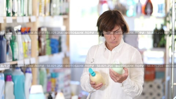 Female buyer chooses liquid hand soap in household goods department of the supermarket. Стоковое видео, видеограф Яков Филимонов / Фотобанк Лори