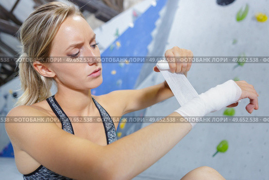 female climber bandaging her wrist. Стоковое фото, агентство Ingram Publishing / Фотобанк Лори