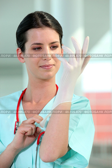 female doctor putting on rubber gloves. Стоковое фото, агентство Ingram Publishing / Фотобанк Лори