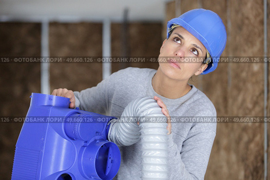 female electrician installing ventilation in ceiling. Стоковое фото, агентство Ingram Publishing / Фотобанк Лори