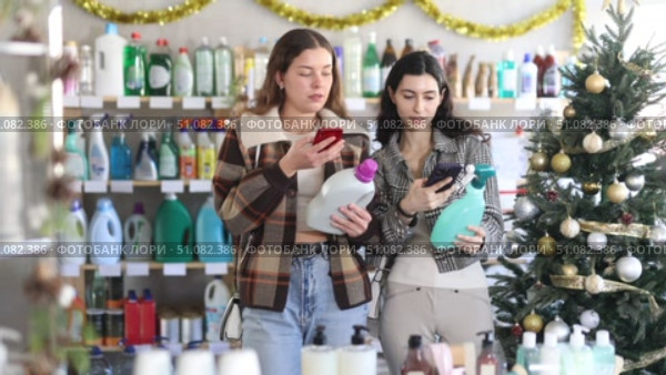 Female friends client scanning QR code on package laundry fabric softener and tile cleaner. Стоковое видео, видеограф Яков Филимонов / Фотобанк Лори