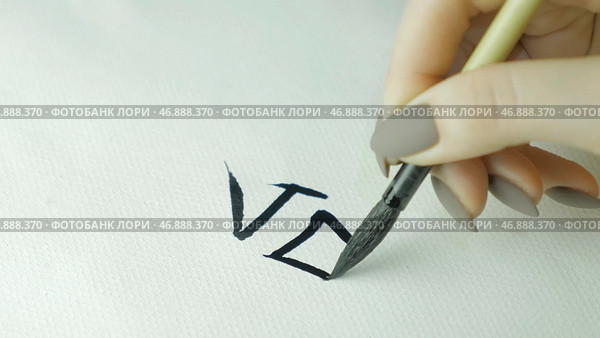 Female hand holding a writing brush calligraphy Chinese characters, close up. Стоковое фото, фотограф David Kashakhi / Фотобанк Лори