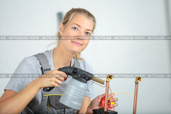 female jeweller blowing a torch. Стоковое фото, агентство Ingram Publishing / Фотобанк Лори