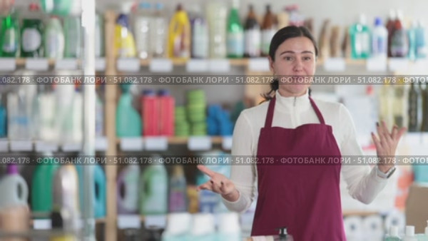Female saleswoman friendly invites to shop in the household department of a supermarket. Best seller offers purchases on promotions and new arrivals. Стоковое видео, видеограф Яков Филимонов / Фотобанк Лори
