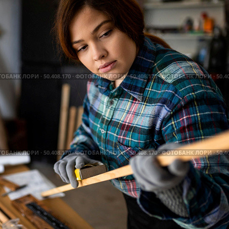 female scrapping wood plank. Стоковое фото, агентство Ingram Publishing / Фотобанк Лори