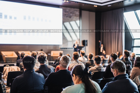 Female speaker giving a talk on corporate business conference. Unrecognizable people in audience at conference hall. Business and Entrepreneurship event. Стоковое фото, фотограф Matej Kastelic / Фотобанк Лори