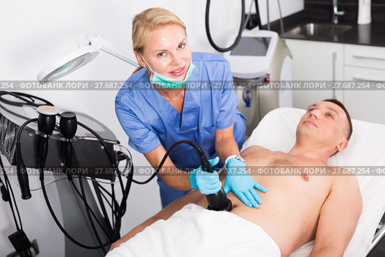 Female specialist is massaging with vacuum to belly of client for anti-fat. Стоковое фото, фотограф Яков Филимонов / Фотобанк Лори