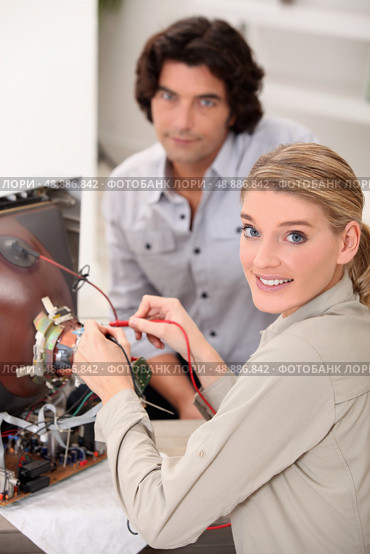 female technician repairing television. Стоковое фото, агентство Ingram Publishing / Фотобанк Лори
