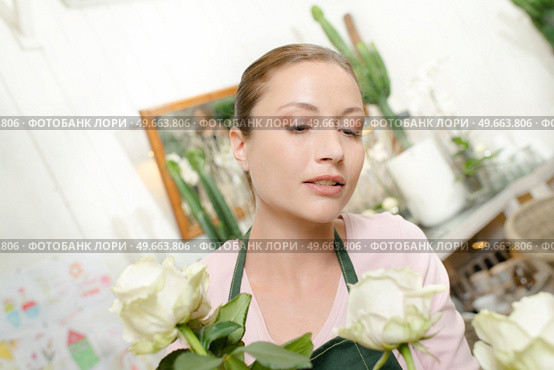 female worker looking at her flowers. Стоковое фото, агентство Ingram Publishing / Фотобанк Лори