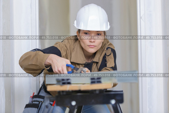 female worker using pliers working on workbench. Стоковое фото, агентство Ingram Publishing / Фотобанк Лори