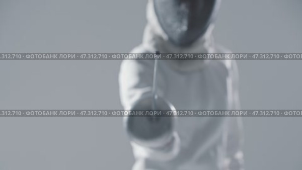 Fencing - young woman fencer in white suit puts on her protective helmet and aiming in the camera with a rapier. Стоковое видео, видеограф Константин Шишкин / Фотобанк Лори