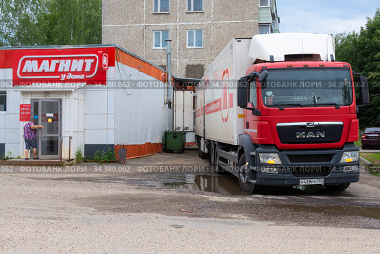 Фирменная фура стоит на разгрузке товара около сетевого магазина "Магнит" (2020 год). Редакционное фото, фотограф Мария / Фотобанк Лори