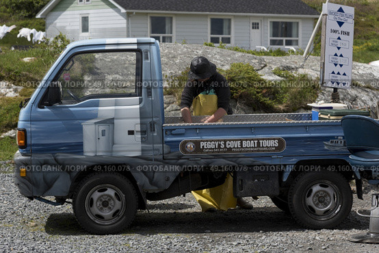 Fisherman loading equipment on truck, Peggy's Cove, Nova Scotia, Canada. Стоковое фото, агентство Ingram Publishing / Фотобанк Лори