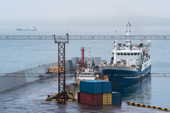 Fishing boat at the pier in the harbor on the shore of a cloudy sea. Стоковое фото, фотограф Евгений Харитонов / Фотобанк Лори