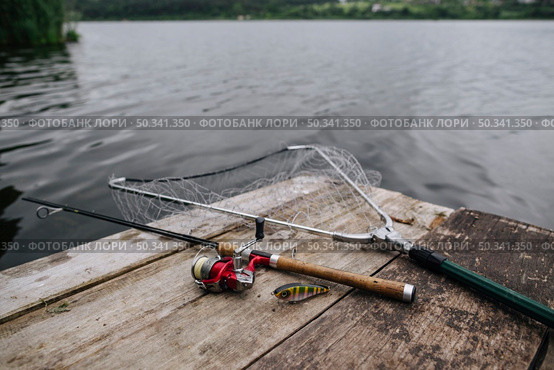 fishing rod with lure net wooden pier idyllic lake. Стоковое фото, агентство Ingram Publishing / Фотобанк Лори