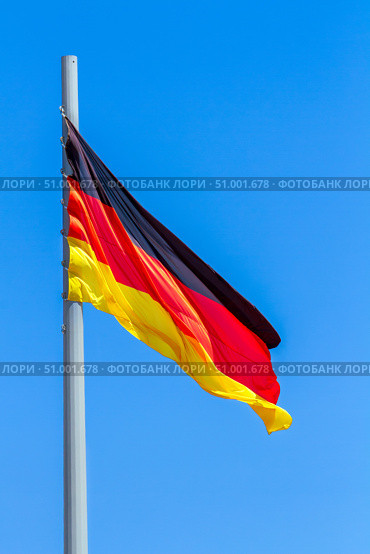 Flag of Germany waving in the wind against the blue sky background. Стоковое фото, фотограф Nobilior / Фотобанк Лори