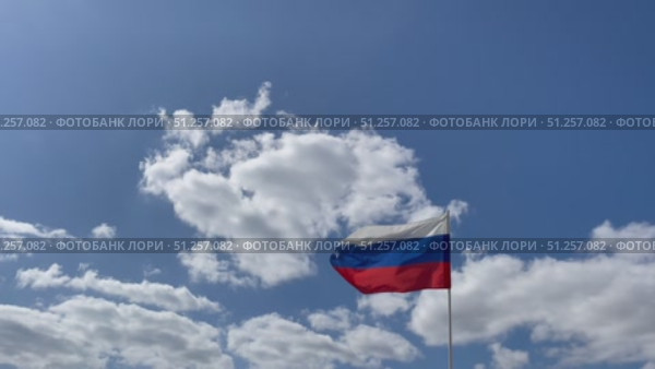 Флаг Российской Федерации развевается на фоне синего неба и облаков. Стоковое видео, видеограф Щеголева Ольга / Фотобанк Лори