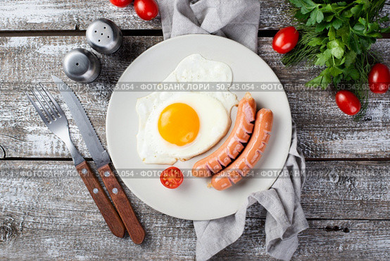 flat lay breakfast sausages egg plate with tomatoes cutlery. Стоковое фото, агентство Ingram Publishing / Фотобанк Лори