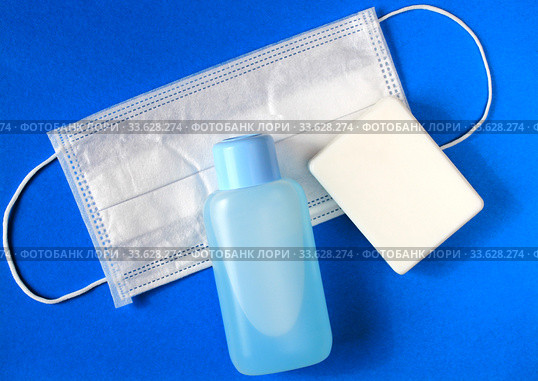 Flat lay of soap, medical surgical mask and hand sanitize on blue background. Стоковое фото, фотограф Попова Ольга / Фотобанк Лори