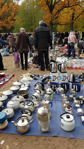 Flea market with goods laid out on the ground and customers (2019 год). Редакционное фото, фотограф Анна Кривицкая / Фотобанк Лори