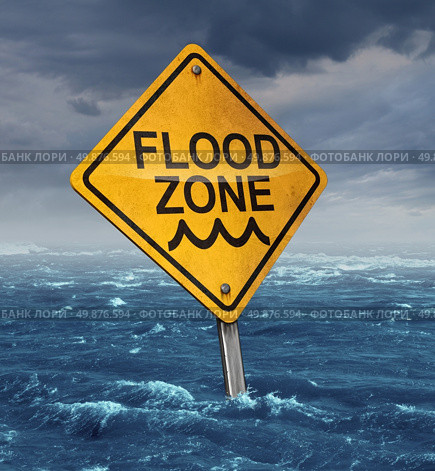Flood warning concept with a yellow traffic sign flooded with water on a dangerous dark stormy cloud sky as a symbol of insurance risk and weather hazards as a natural disaster. Стоковое фото, агентство Ingram Publishing / Фотобанк Лори