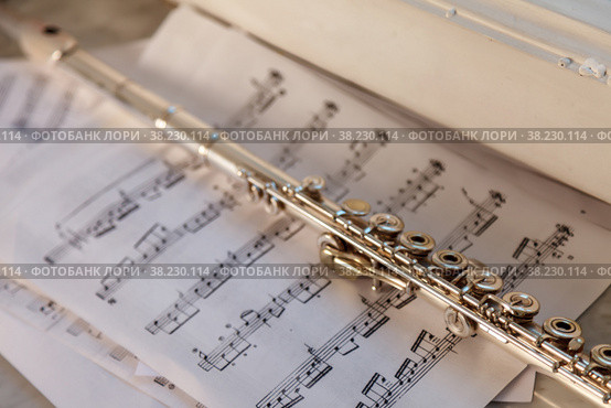 Flute And Sheet Music. Cross flute on a sheet of music. Silver flute on an old musical background. Classical soprano saxophone. Стоковое фото, фотограф Aleksandr Golubev / Фотобанк Лори