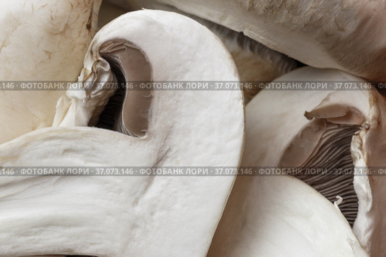 Food background. Sliced champignon mushroom close-up. Low-calorie product, a source of vitamin B1, B2, B6, B12, D6, D12, nicotinic pantothenic acid, iron, zinc, calcium, iodine, phosphorus, protein. Стоковое фото, фотограф Светлана Евграфова / Фотобанк Лори