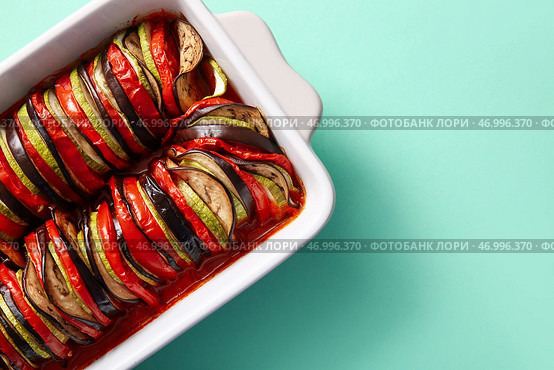 Форма для выпечки вкусного рагу из овощей на бирюзовом фоне. Стоковое фото, фотограф Pixel_shot / Фотобанк Лори