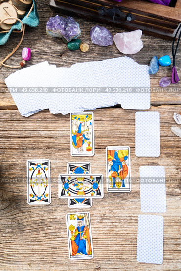 Fortune telling on tarot cards, deck are placed in cross figure, top view, used Marseille Tarot deck by unknown artist published first in 1709. Fortune telling on tarot cards. Стоковое фото, агентство Ingram Publishing / Фотобанк Лори